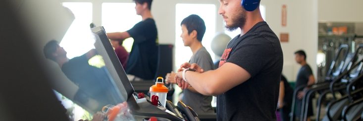 Man checking his watch on a treadmill