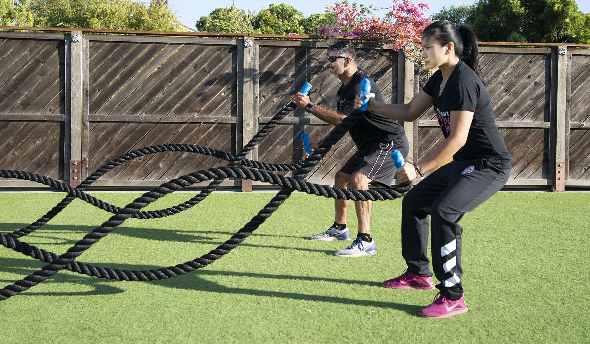 Man and woman tugging rope outdoor exercise class