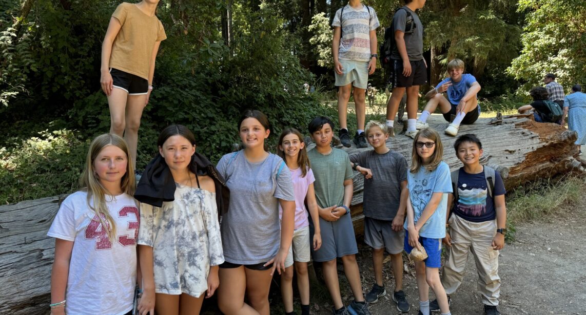 summer camp, 15 teens leaning on a log