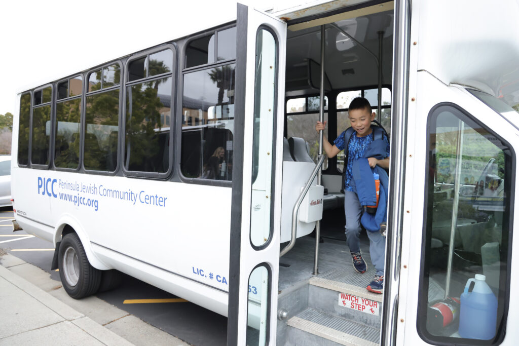 May contain one person getting on a white bus.